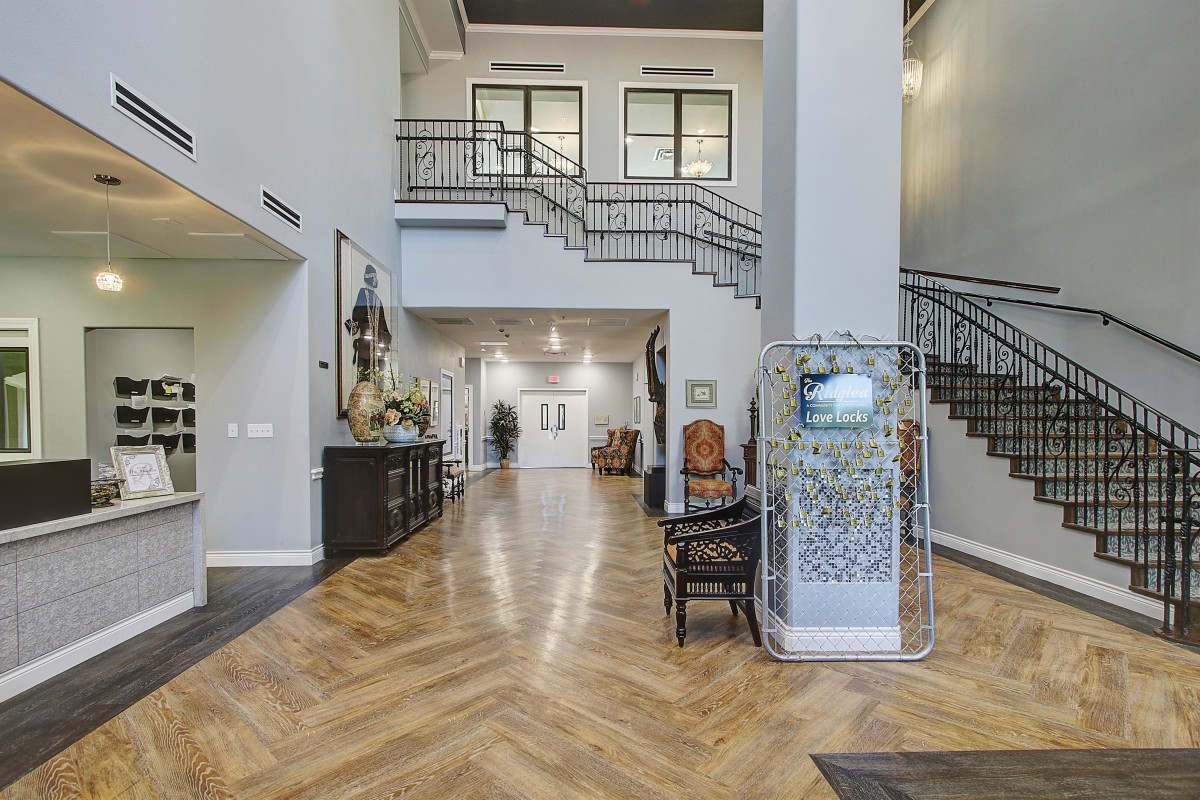 A luxurious interior space featuring a grand staircase and elegant wood flooring.