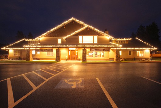 A well-lit building at night with lights highlighting its architecture, set beside an empty parking lot.