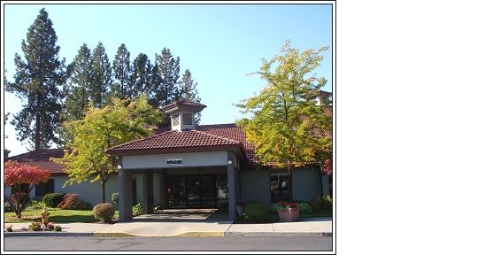 A small building with a red tiled roof surrounded by trees on a sunny day.