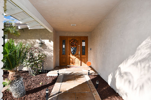 Welcoming entrance to a beautiful home with a well-defined pathway and stylish door.