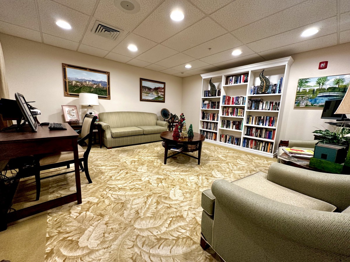A cozy living room with sofas, a bookshelf, and elegant decor.