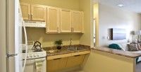A small kitchen with light wooden cabinets and a stove.