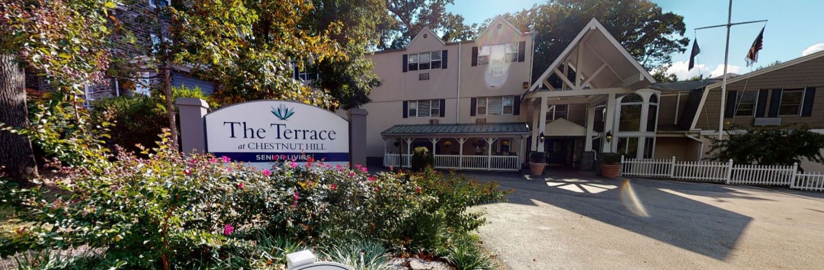 Exterior view of a residential building with a sign and garden.