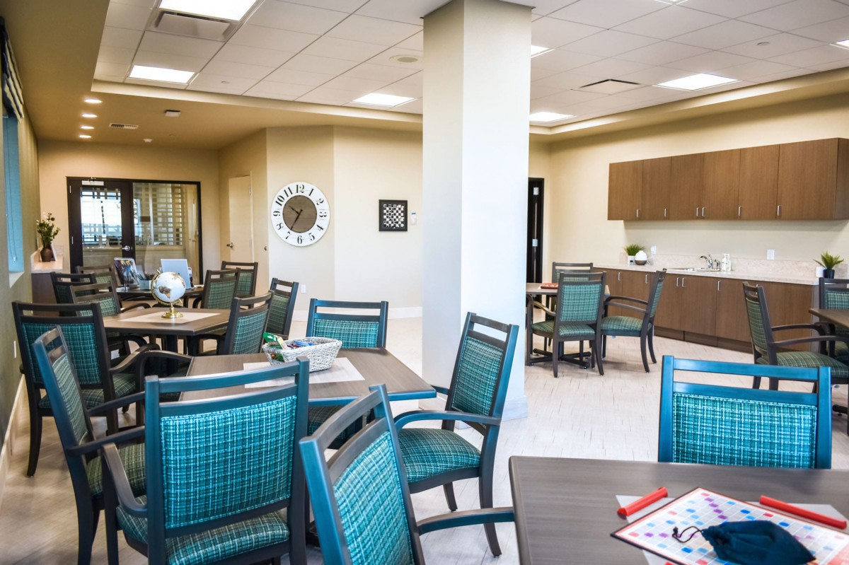 A modern room with a seating area and kitchenette.