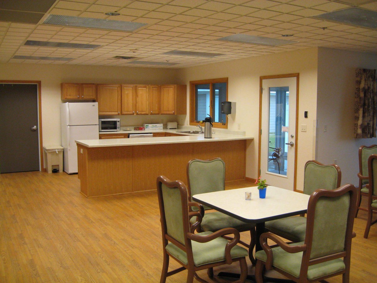 A cozy kitchen and dining area with wooden cabinets and a table set for four.
