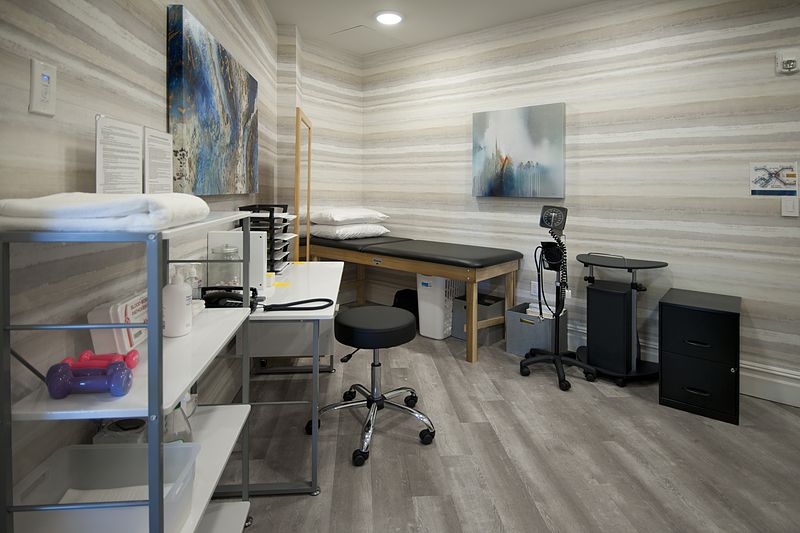 A clean and organized medical examination room with necessary equipment.
