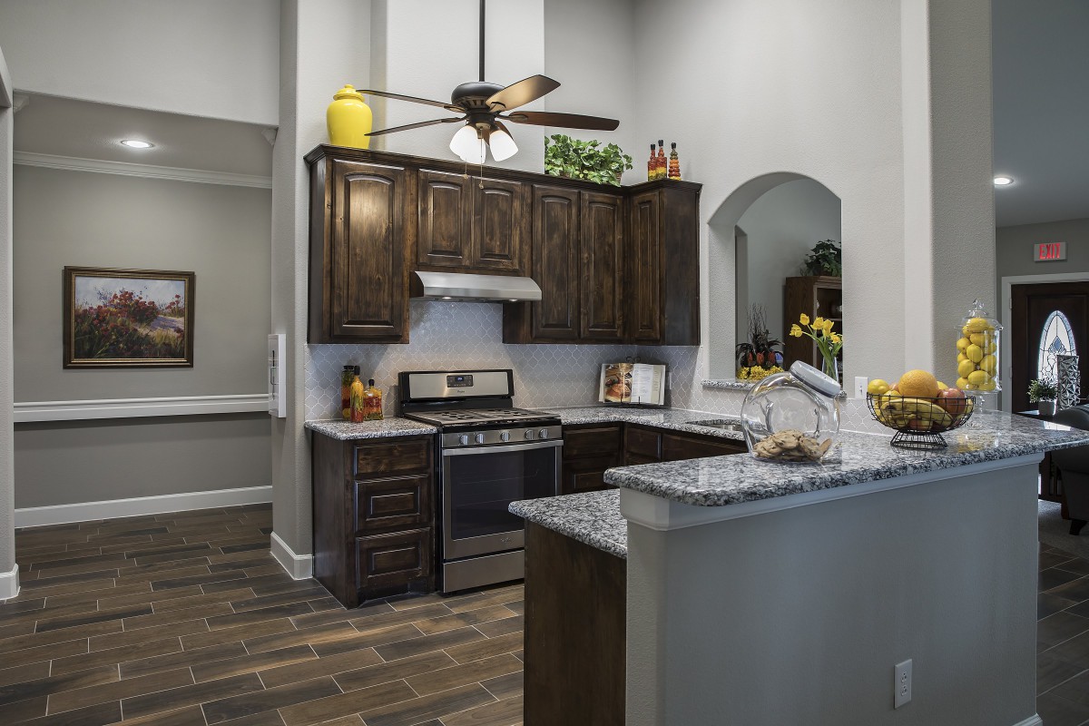 Modern kitchen interior with dark wood cabinets and granite countertops.