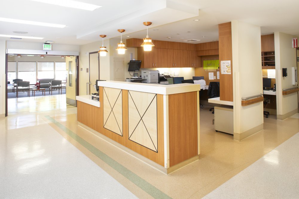 A hospital reception area with a central desk and bright lighting.