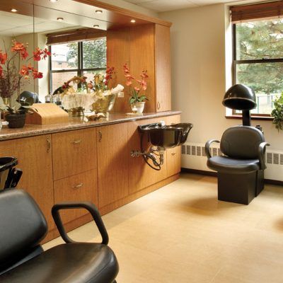 A bright and tidy hair salon interior with mirrors, chairs, and floral decorations.