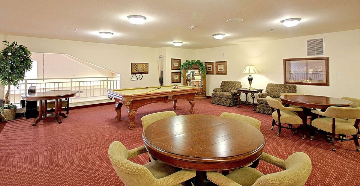 A cozy game room featuring a pool table and comfortable seating area.