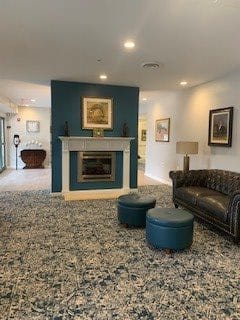 A cozy living room with a fireplace, decorated with artwork and a comfortable sofa.