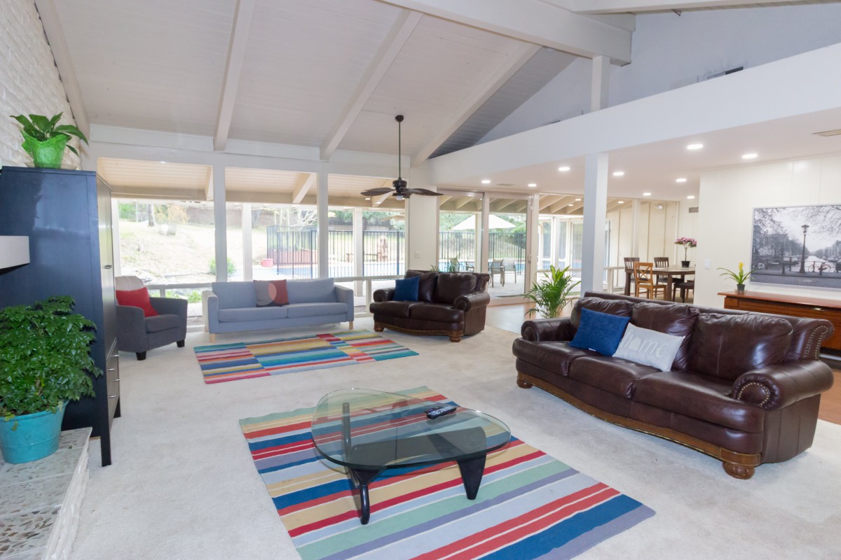 A spacious and modern living room with comfortable sofas and colorful rugs.