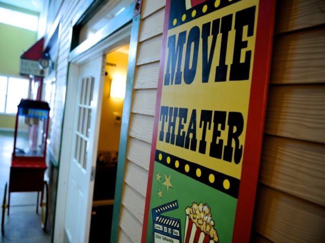 A vintage-style movie theater sign with popcorn illustration.