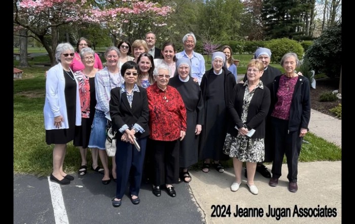 A group of people gathered outdoors for a photo, labeled '2024 Jeanne Jugan'.