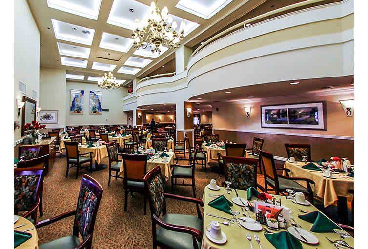 A well-appointed dining area with elegantly set tables and chandeliers.