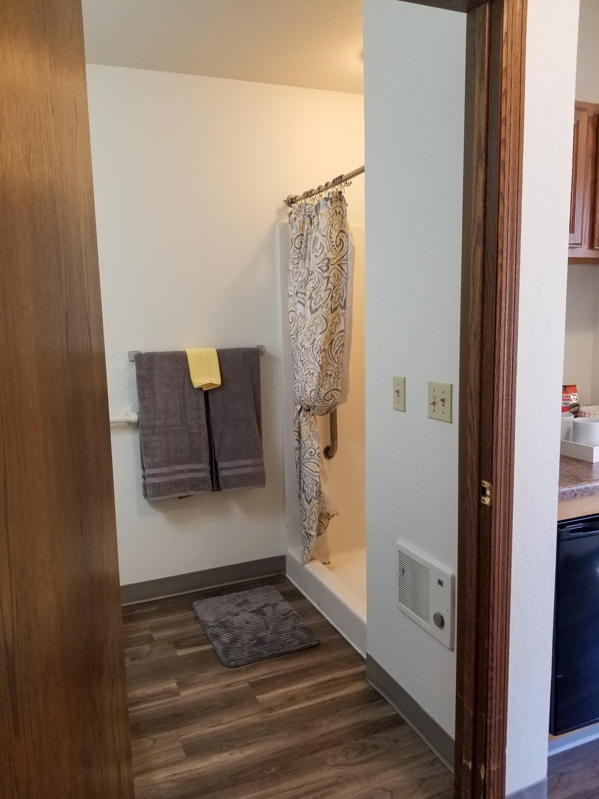 A view of a bathroom with a shower and towels neatly arranged.