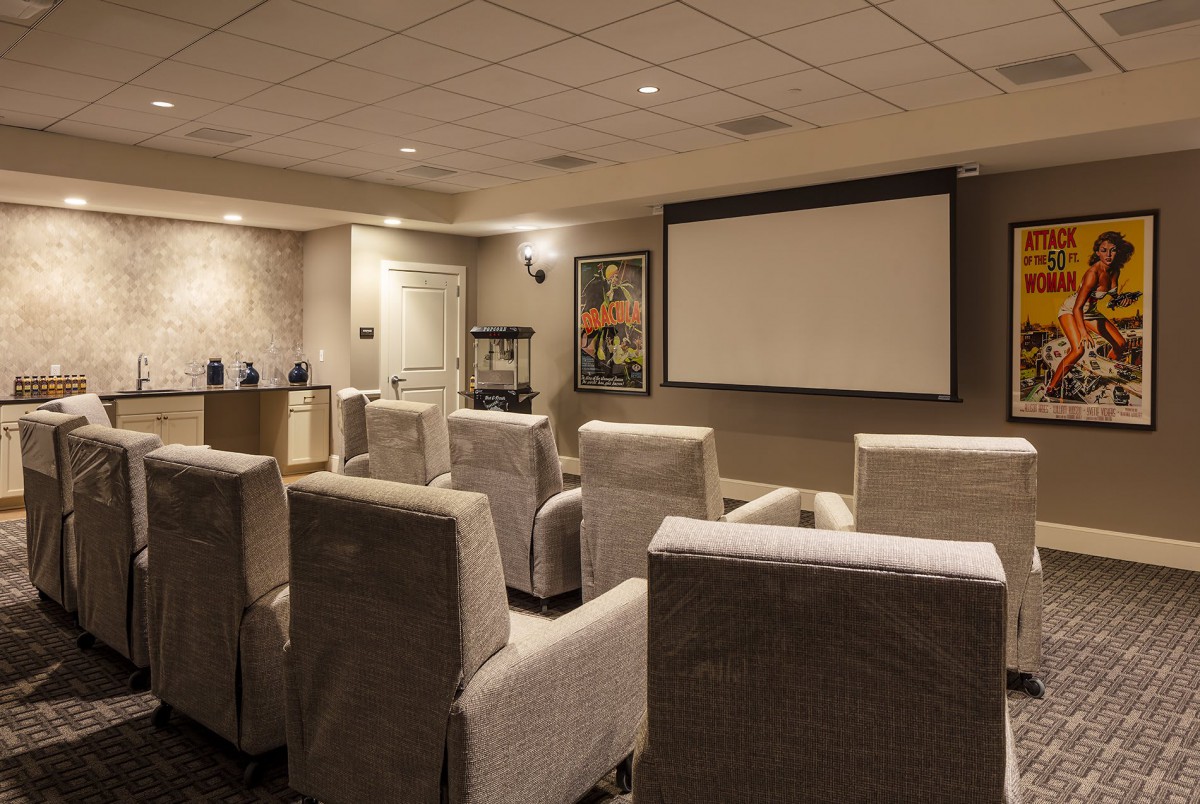 A cozy home theater with comfortable seating and a large projection screen.