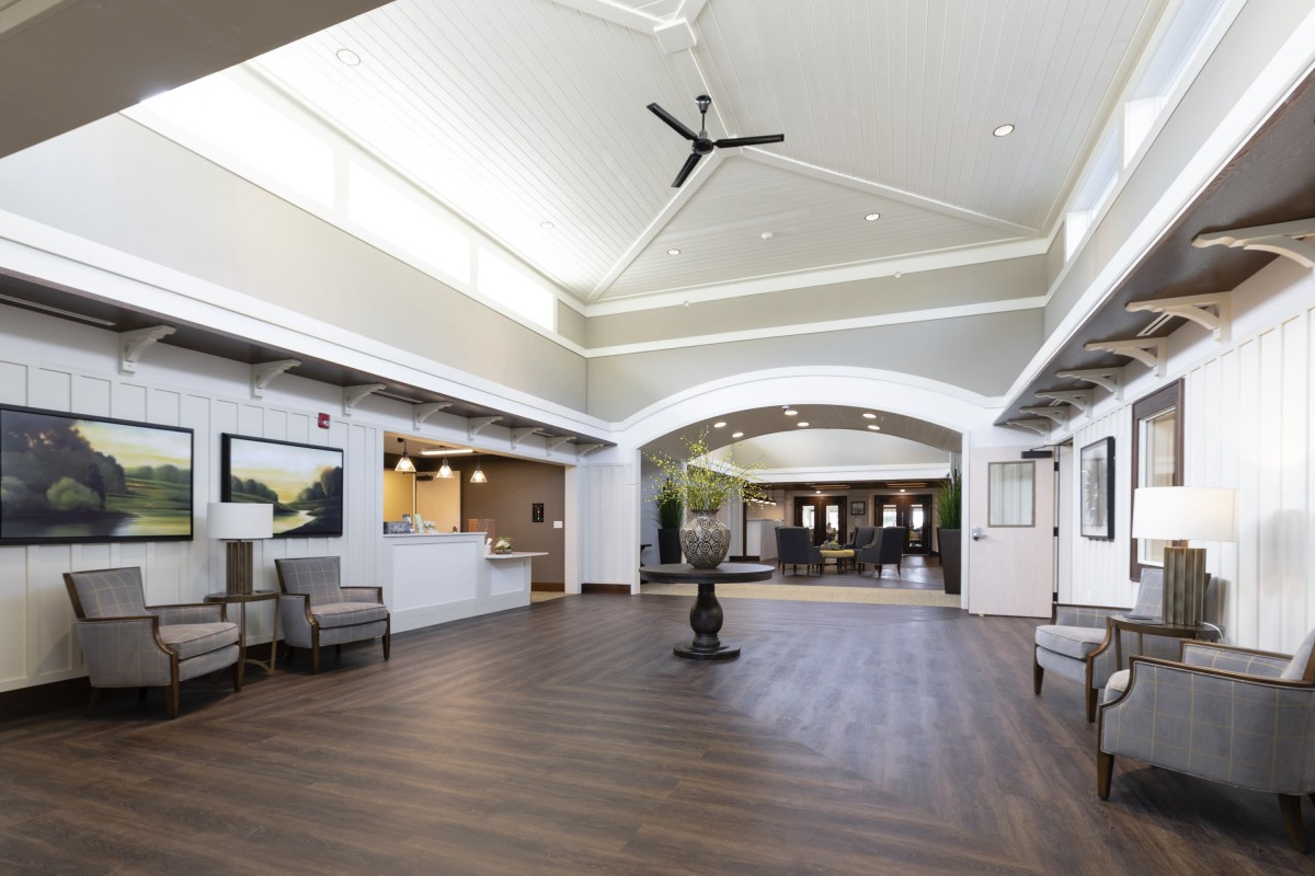A spacious and modern lobby with a reception desk and seating area.