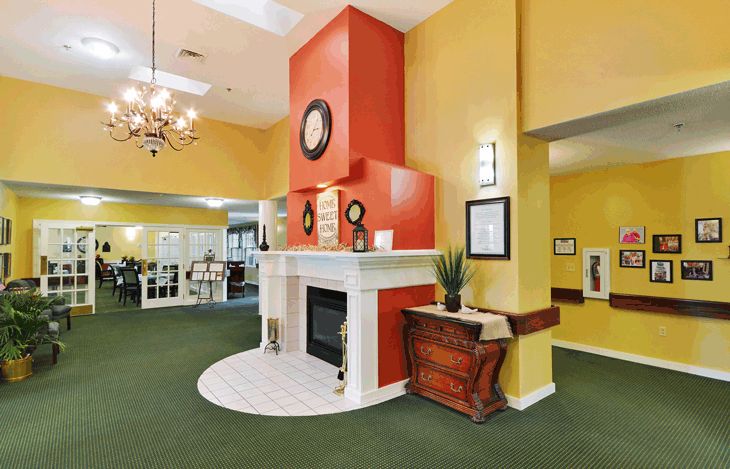 A brightly colored lobby with a central fireplace and decorative elements.