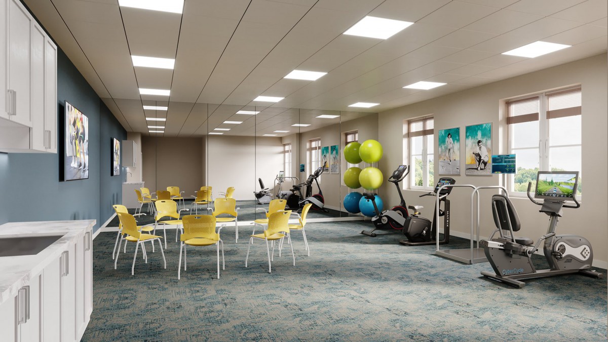 A modern gym space with exercise bikes and colorful fitness balls, complemented by a seating area with yellow chairs and tables.