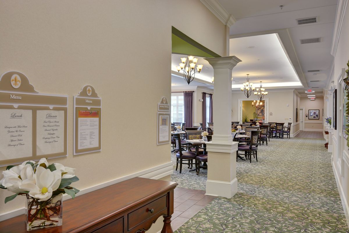 A spacious dining room with elegant furniture and chandeliers.