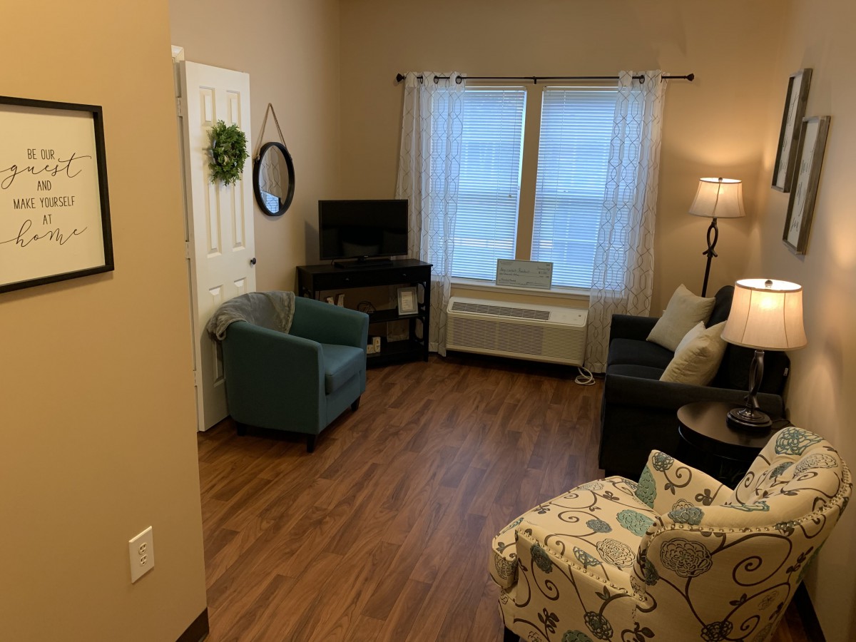 Cozy living room with a sofa, armchairs, and a TV.