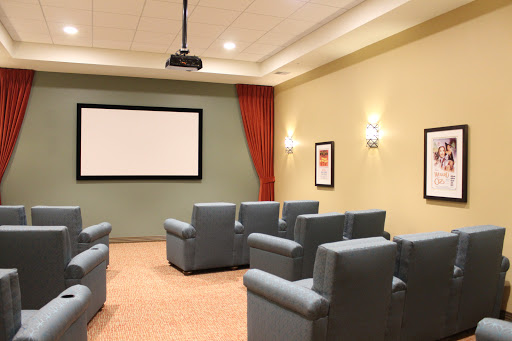 A cozy home theater setup featuring comfortable recliner seating and a projector screen.
