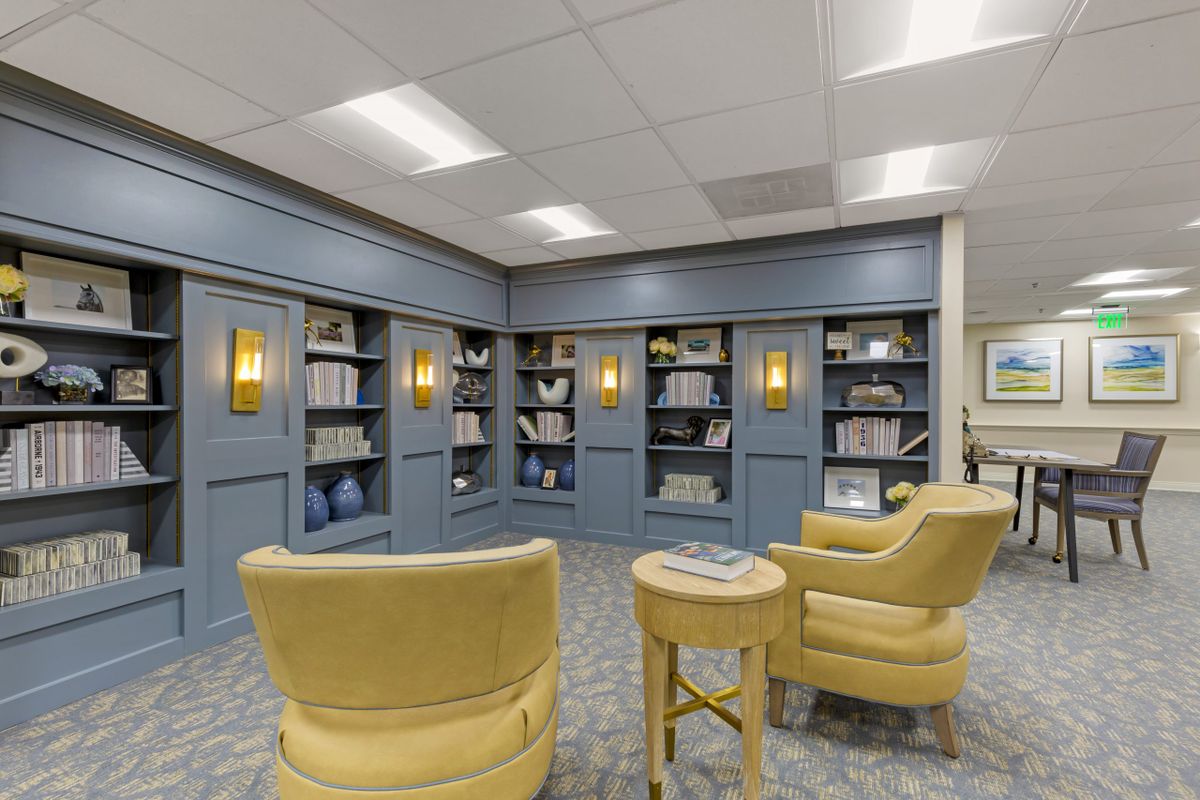 Cozy library nook with blue bookshelves and comfortable seating.