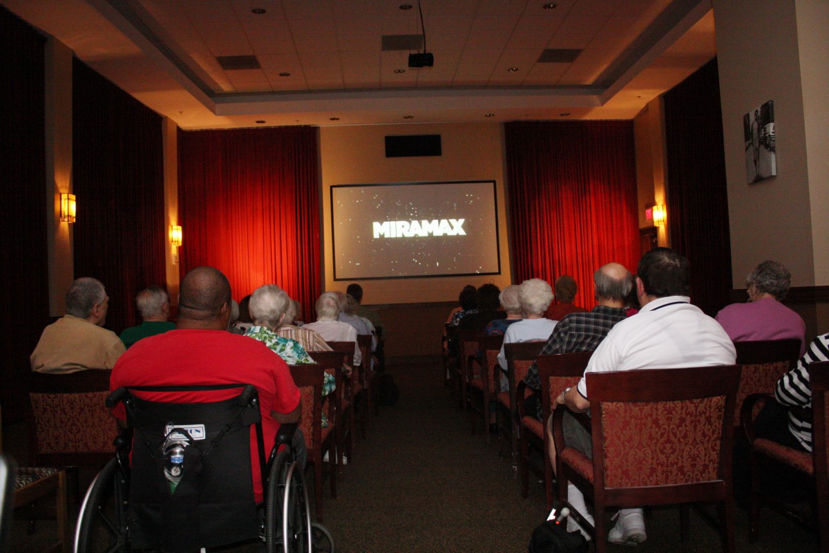 Audience watching a movie in a small theater setting.
