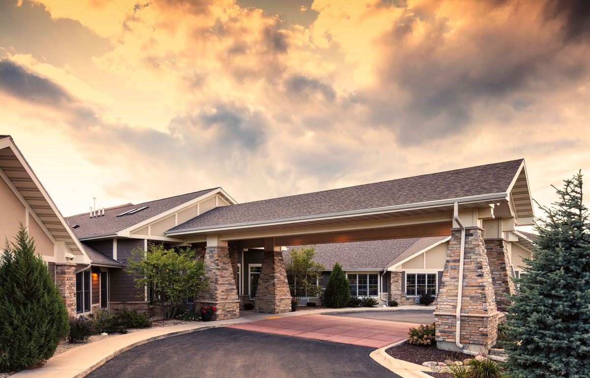 A modern building with a welcoming entrance under a dramatic sunset sky.