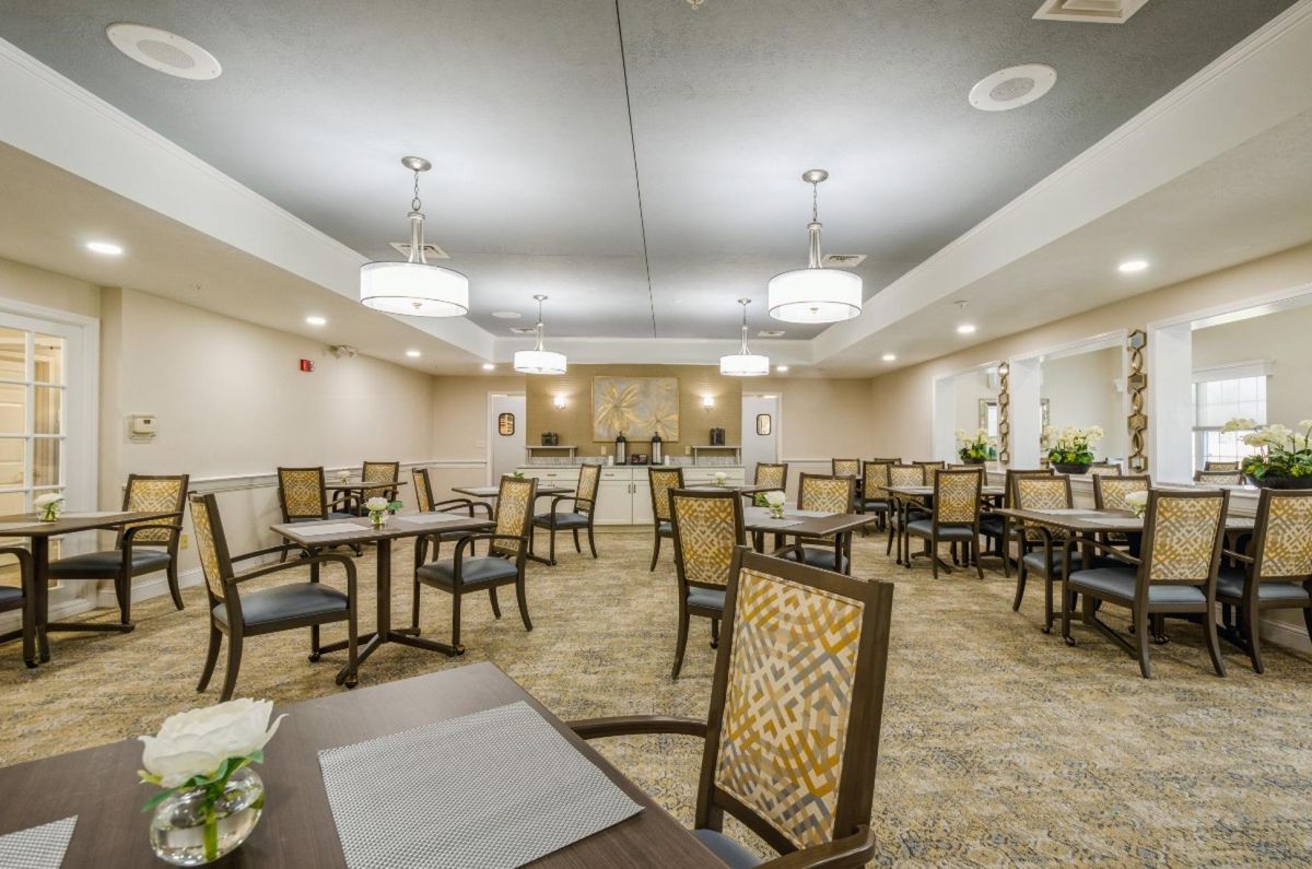 An elegant dining area featuring neatly arranged tables and chairs under soft lighting.
