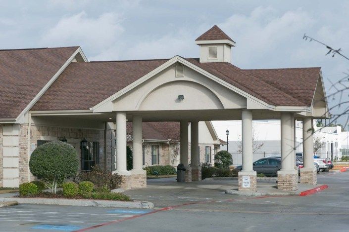 The exterior entrance of a hotel with a covered driveway.