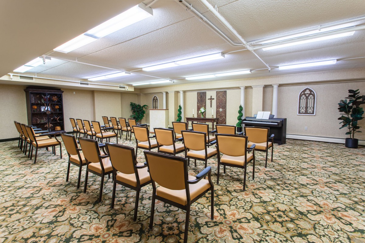 An empty conference room with neatly arranged chairs facing the front.