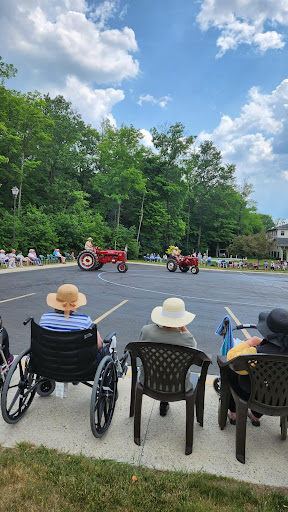 Residents enjoy a lively tractor parade on a sunny day.