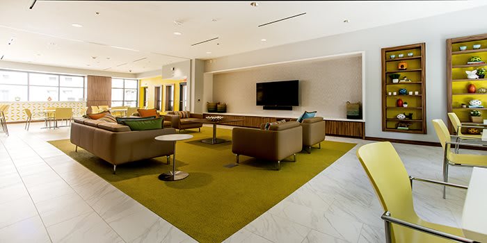 A modern lobby featuring comfortable seating and a large television.