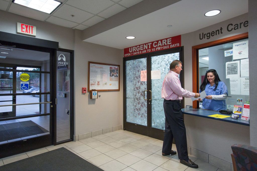 A person checking in at the reception of an urgent care facility.
