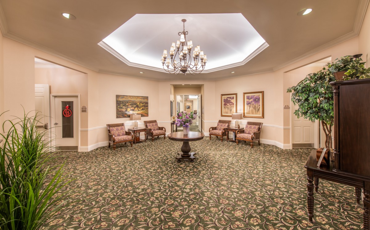 A spacious and elegantly designed lobby featuring a chandelier, comfortable seating, and decorative artwork.