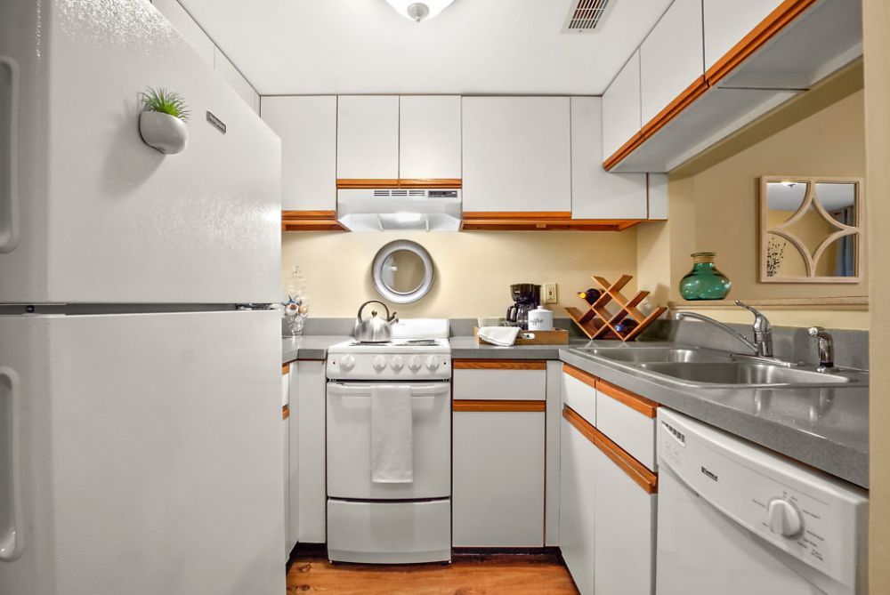 A compact kitchen with white cabinets and modern appliances.