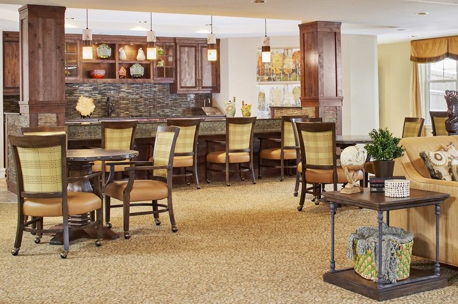 A cozy interior with a bar and seating area featuring comfortable furniture and warm lighting.