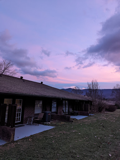 A serene sunset casts a colorful glow over the mountains and buildings.