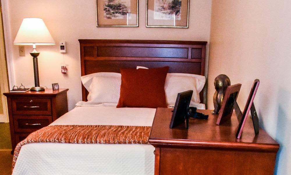 A cozy bedroom with a neatly made bed, featuring decorative pillows and bedside lamps.