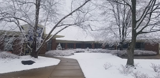 A serene winter scene with a snow-covered building and frosted trees.
