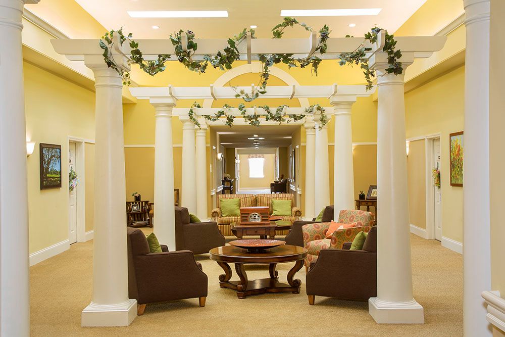 A cozy lobby area featuring comfortable seating and decorative columns enhanced by greenery.