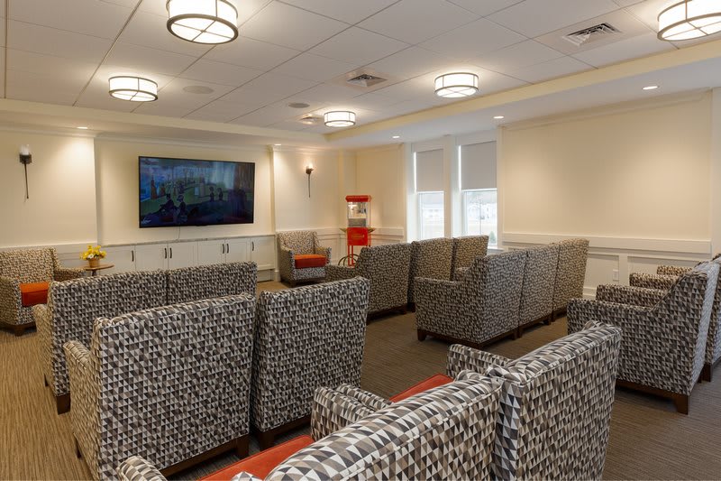 A well-furnished waiting room with multiple seating arrangements and a television.