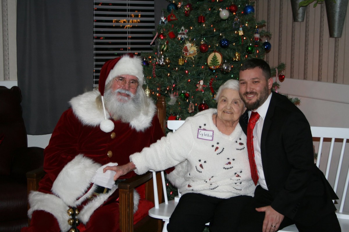 A joyful family photo with Santa Claus in front of a beautifully decorated Christmas tree.