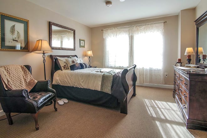 A cozy bedroom with a large bed, bedside lamps, and a mirror on the wall.