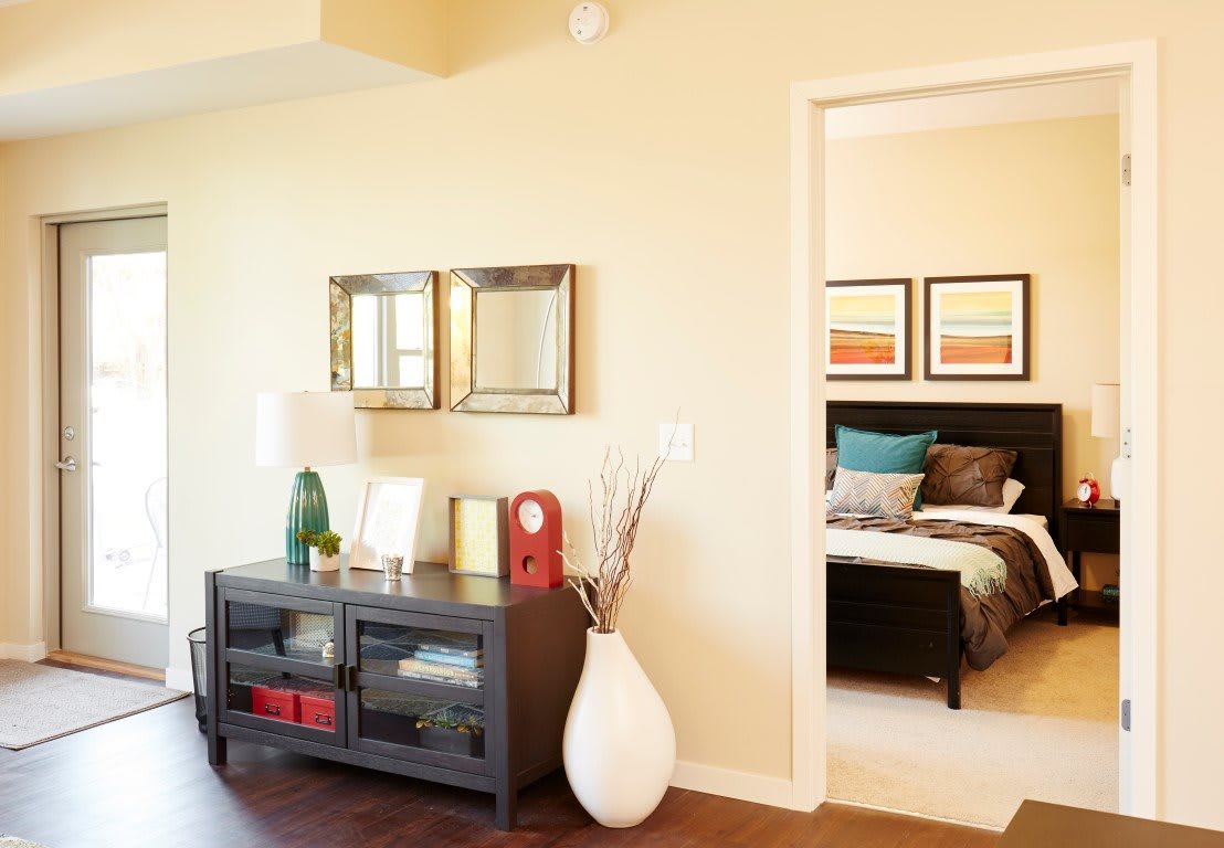 Cozy living area with modern decor and a view into the bedroom.