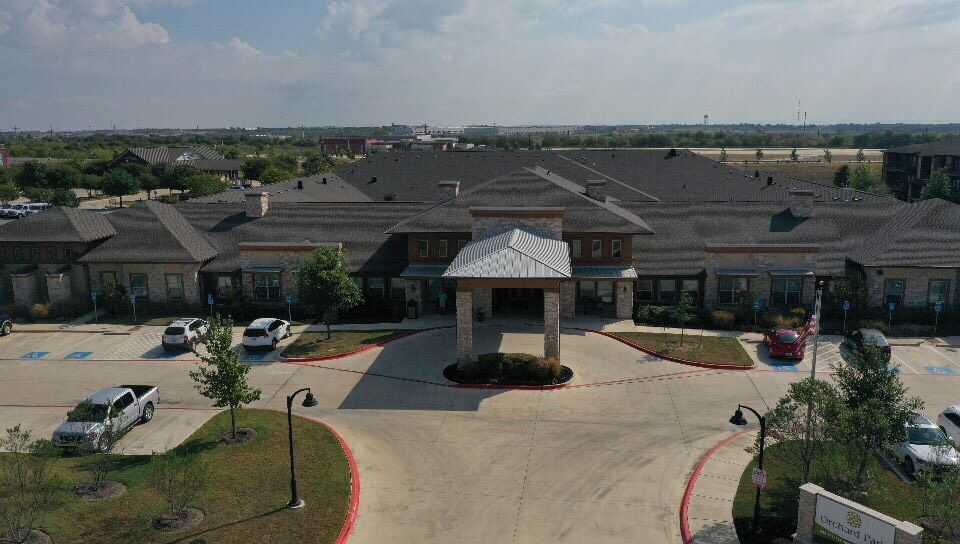 A large building with a main entrance and surrounding landscape.