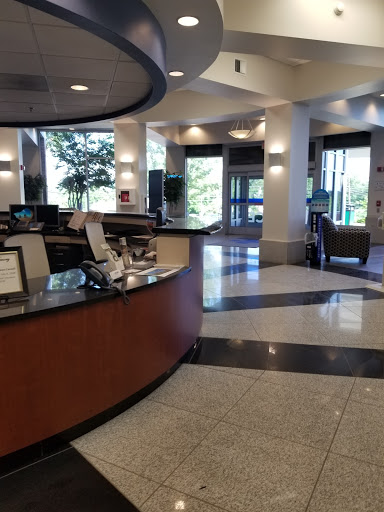 A spacious reception area featuring a modern design with ample seating and natural light.