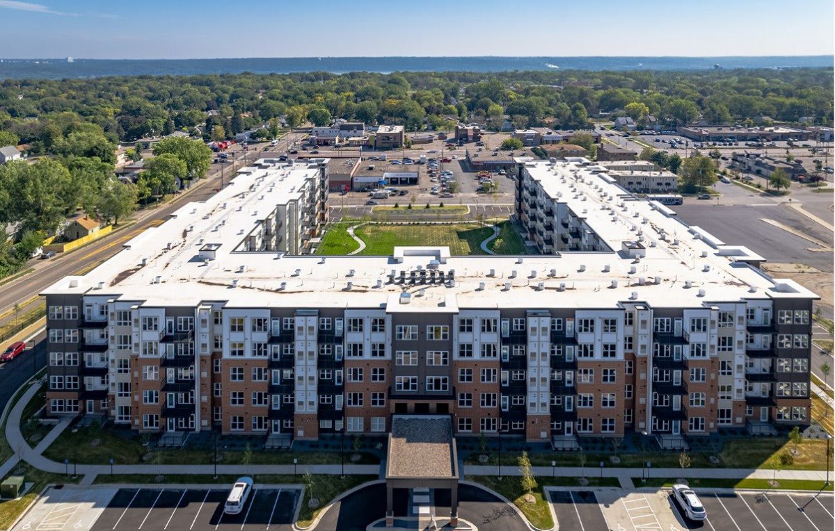 Aerial view of a modern apartment complex with a spacious courtyard in an urban area.